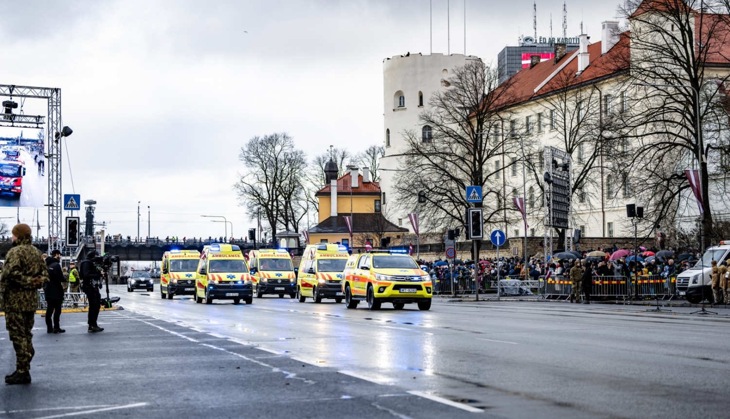 NMPD operatīvie auto brauc pa ielu, fonā prezidenta pils